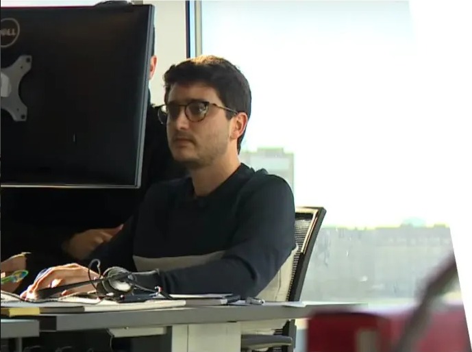 Profile Picture of Eduardo Fernandez (@EFernandez9000), working side by side with a colleague: sitting on a desk, while looking at a screen